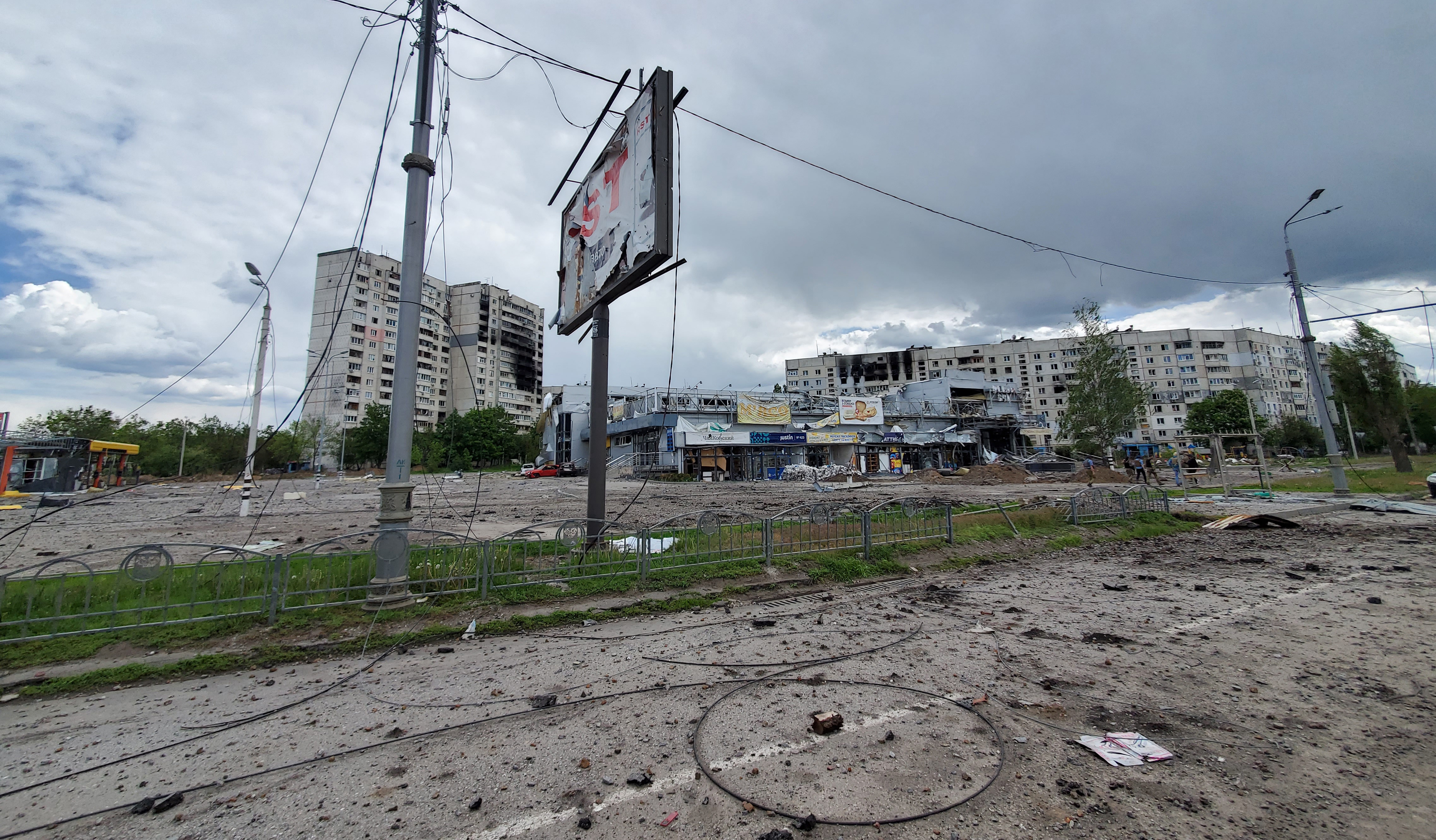 A street in Kharkiv shows buildings and road surfaces damaged by shelling