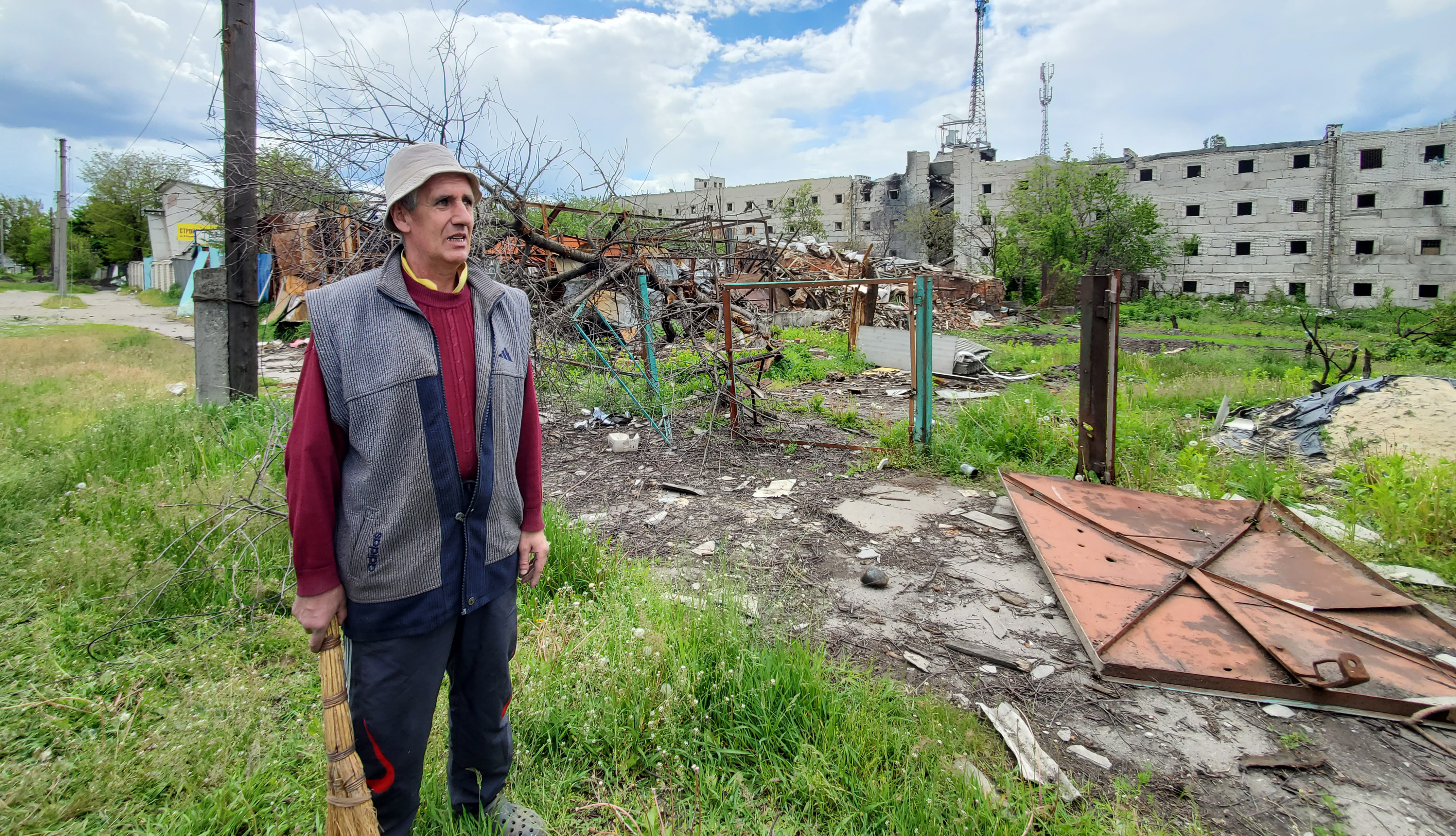 A resident stands beside the wreckage of his destroyed home in Kharkiv